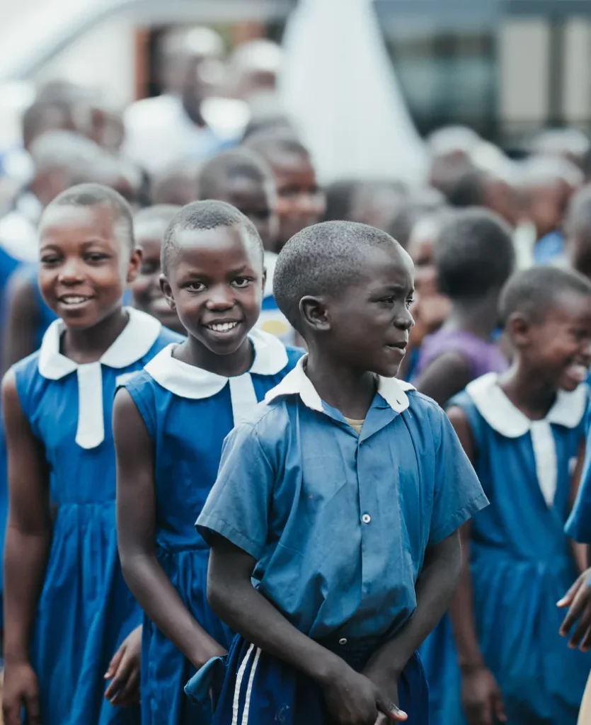 Primary school children in blue uniforms smiling together